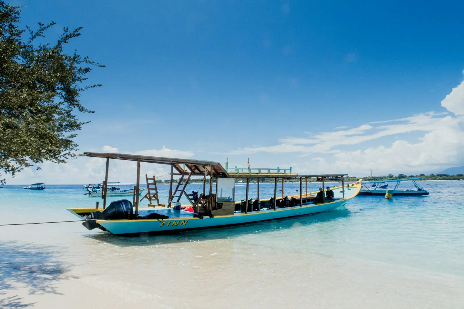 Traditional boat pulled up on a white-sand Gili beach