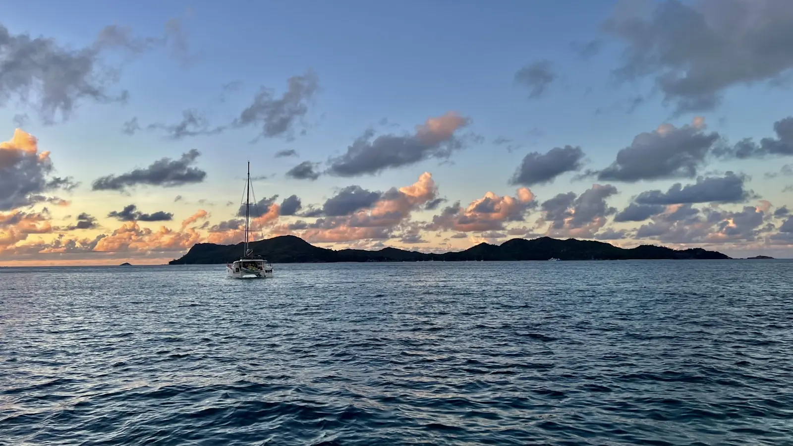 Sailing boat at anchor among islands at dusk